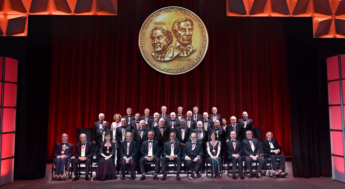 A group of National Inventors Hall of Fame Inductees sit together on the stage during the Induction Ceremony